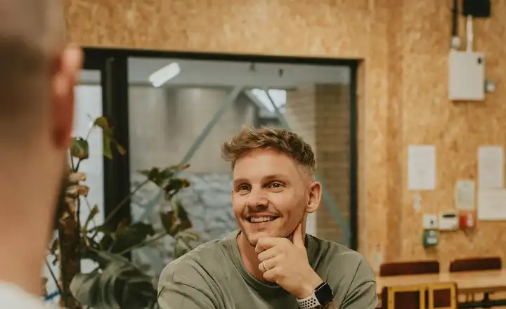 A prospect smiling across the table during a sales conversation