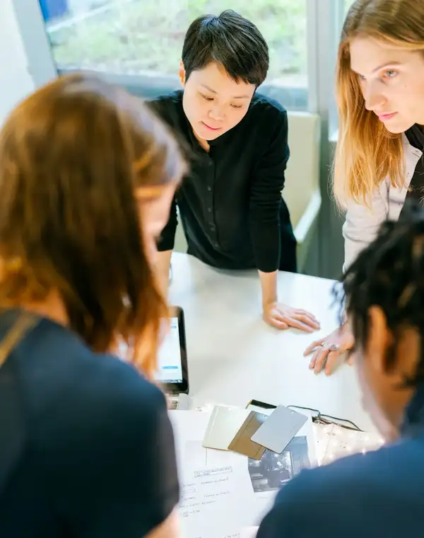 A small founding team gathered around one table reviewing work